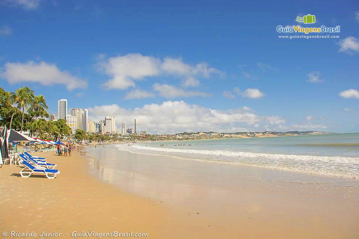 Imagem da praia e ao fundo os prédios.