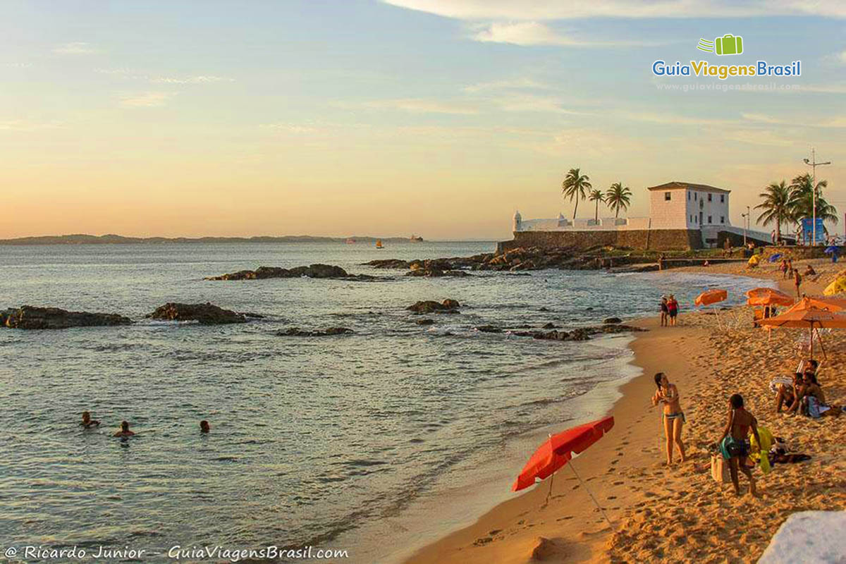 Imagem de criança na Praia Porto da Barra, aproveitando cada segundo do sol.