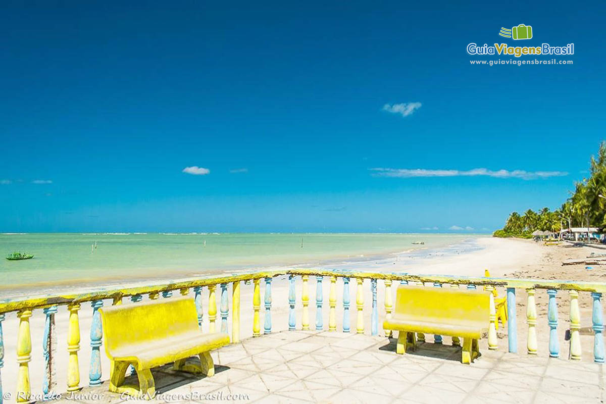 Imagem de cadeiras amarelas na Praia Porto da Rua, em Alagoas.