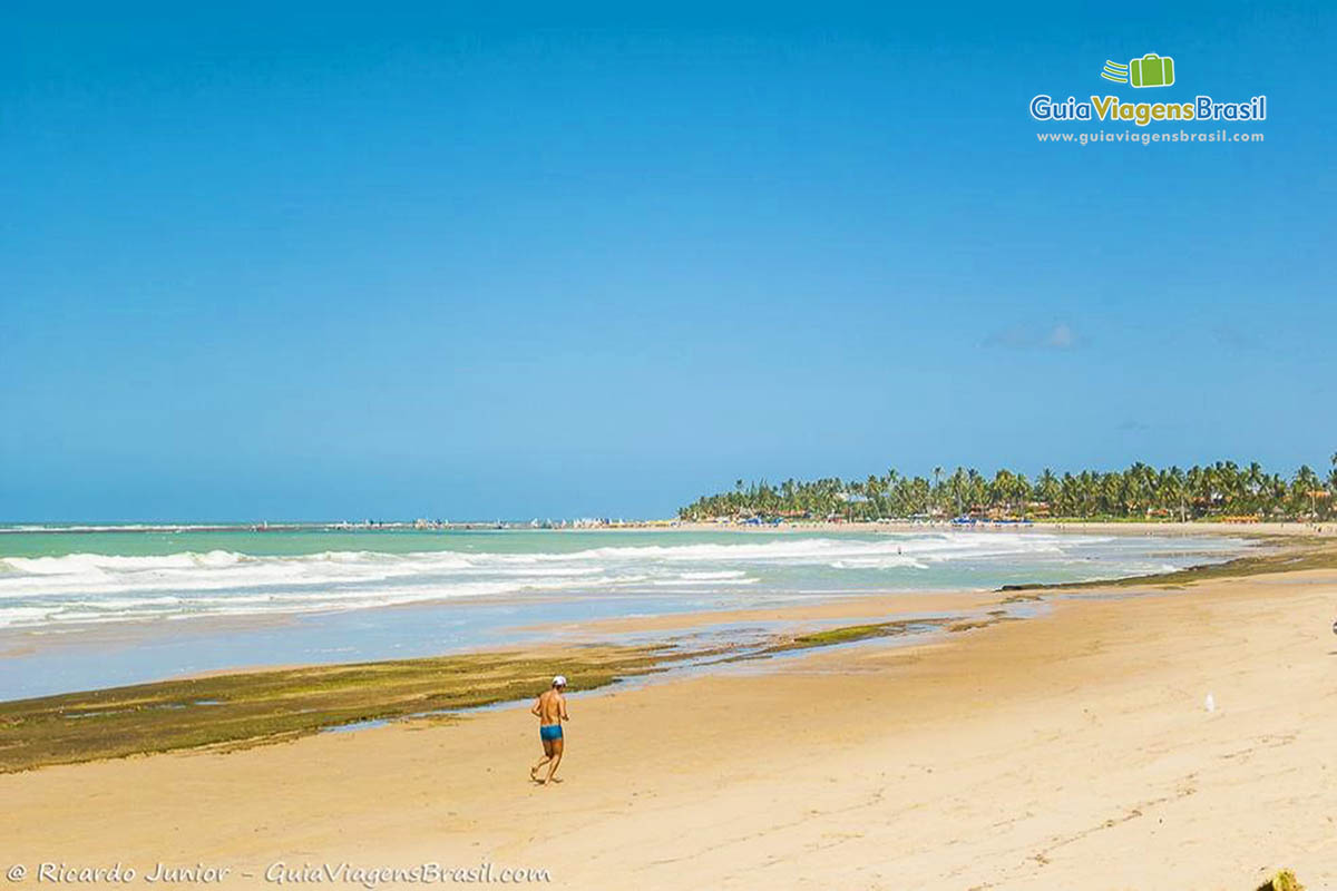 Imagem de uma pessoas caminhando tranquilamente e curtindo a bela Praia Porto de Galinhas.