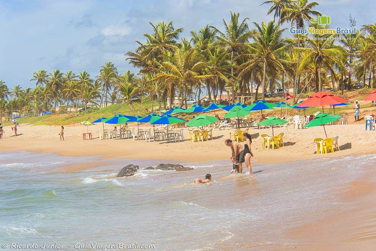 Imagem de família nas águas da praia.