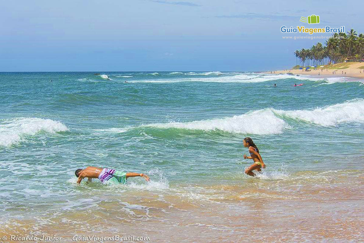 Imagens de duas crianças correndo e mergulhando na praia.