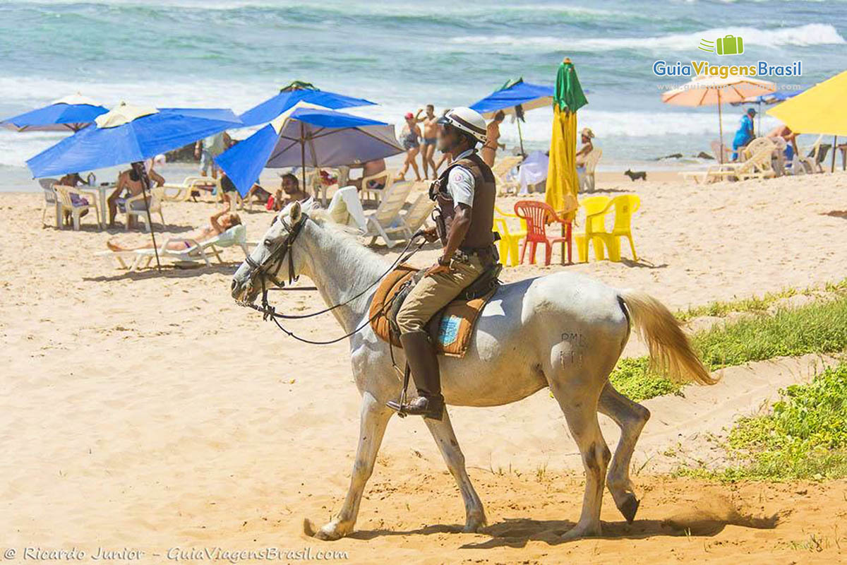 Imagem de guarda no cavalo passeando e protegendo os turistas na Praia Stella Maris.