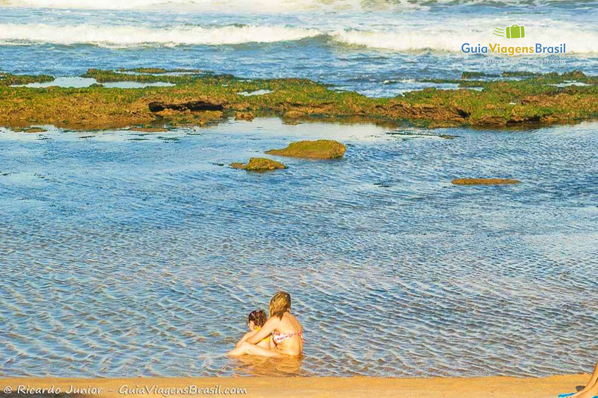 Imagem de uma família nas piscinas natural da linda praia.