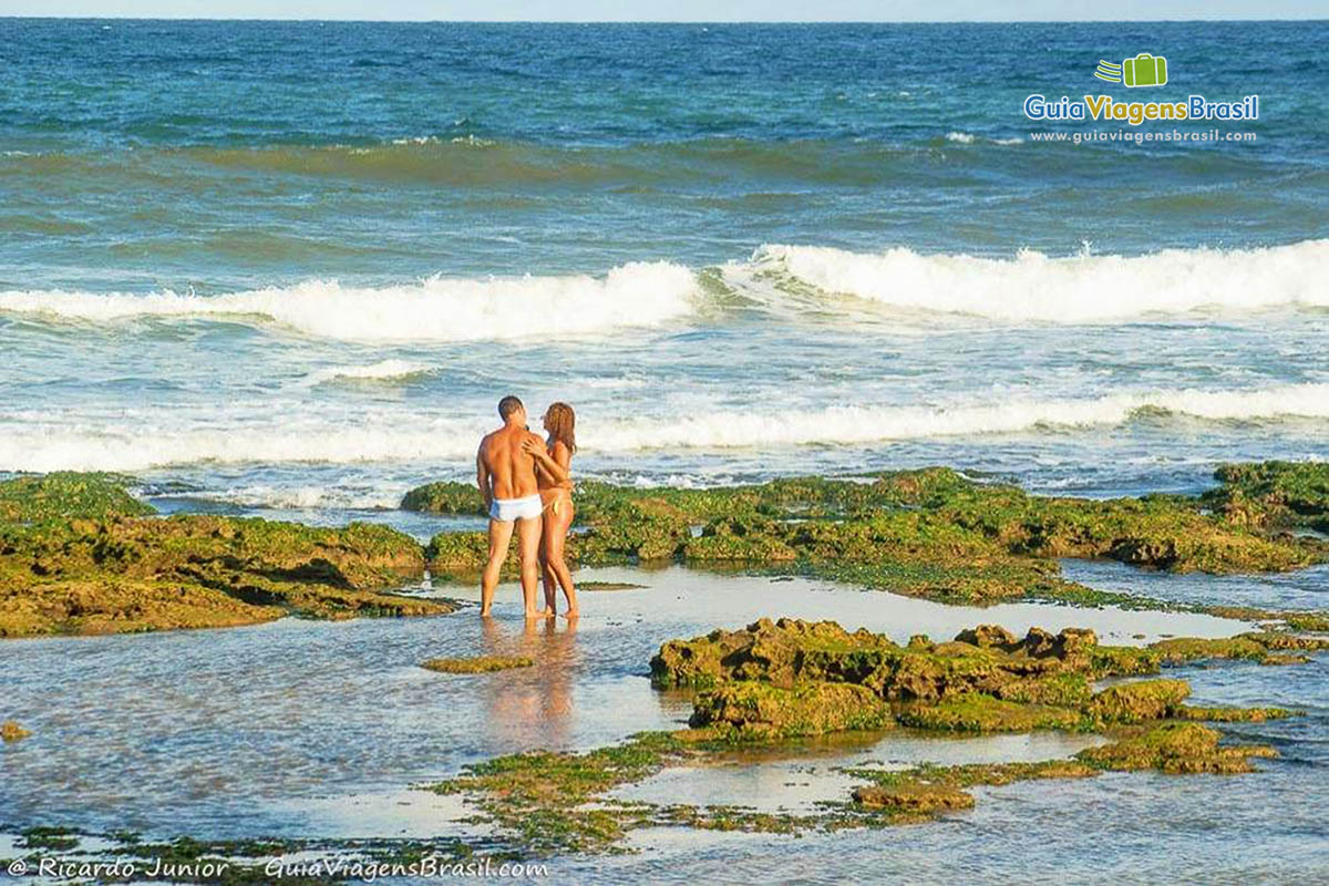 Imagem de um casal nas pisicna naturais.