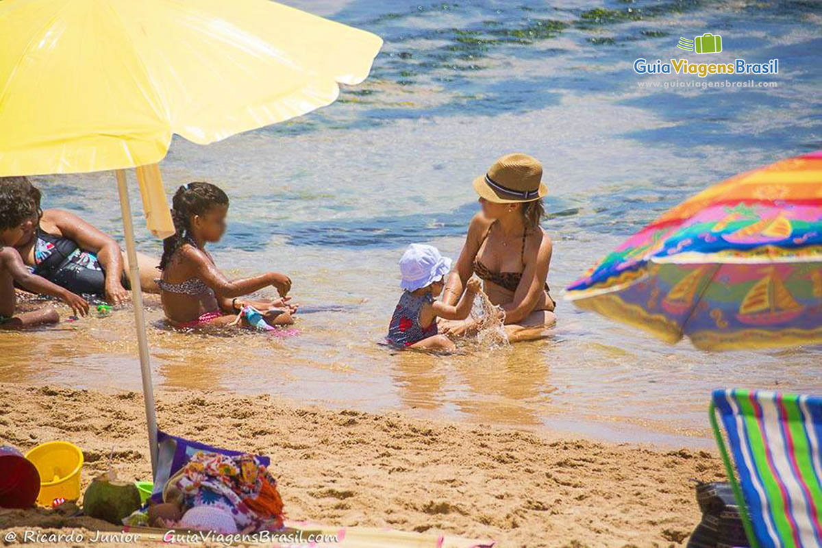 Imagem de crianças na beira da praia.