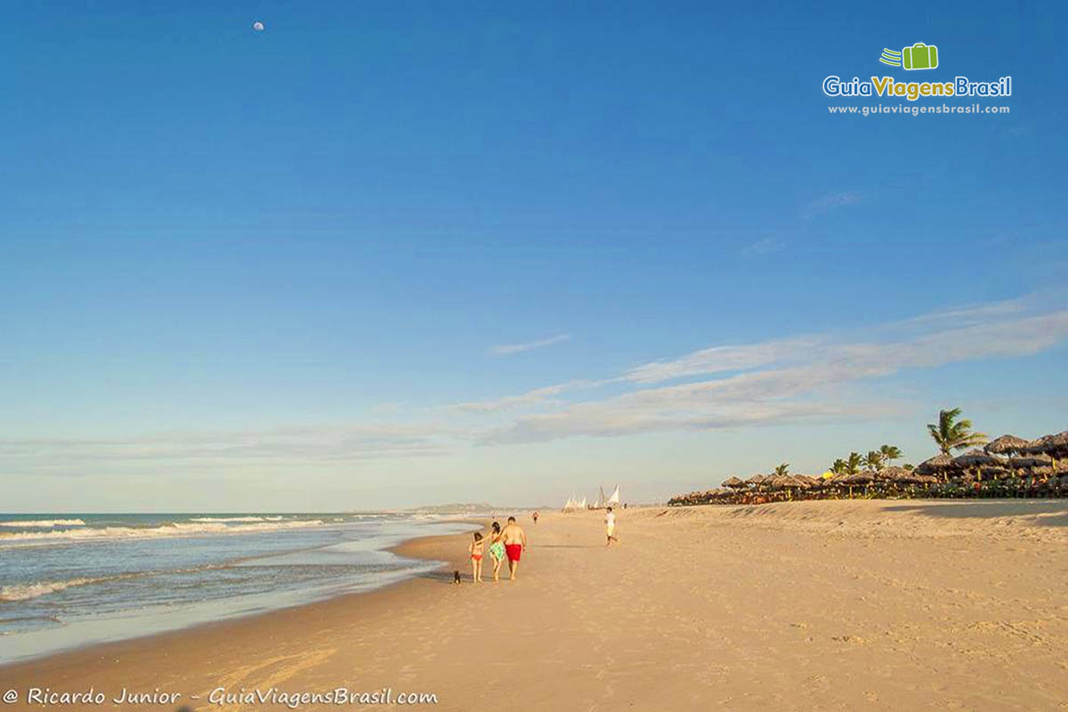 Imagem de uma família caminhando na Prainha em Aquiraz.