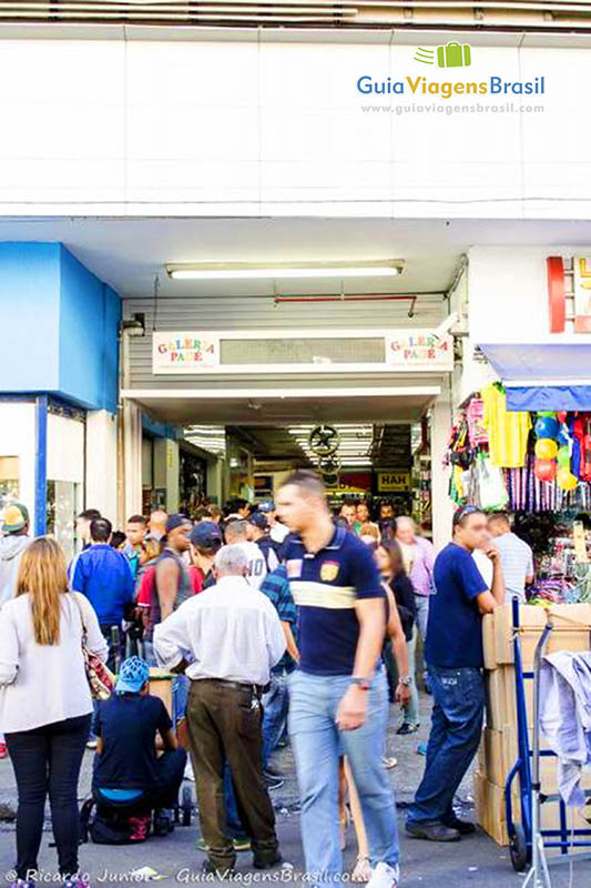 Imagem de pessoas circulando na Rua 25 de Março, maior centro comercial da América Latina, na cidade de São Paulo.