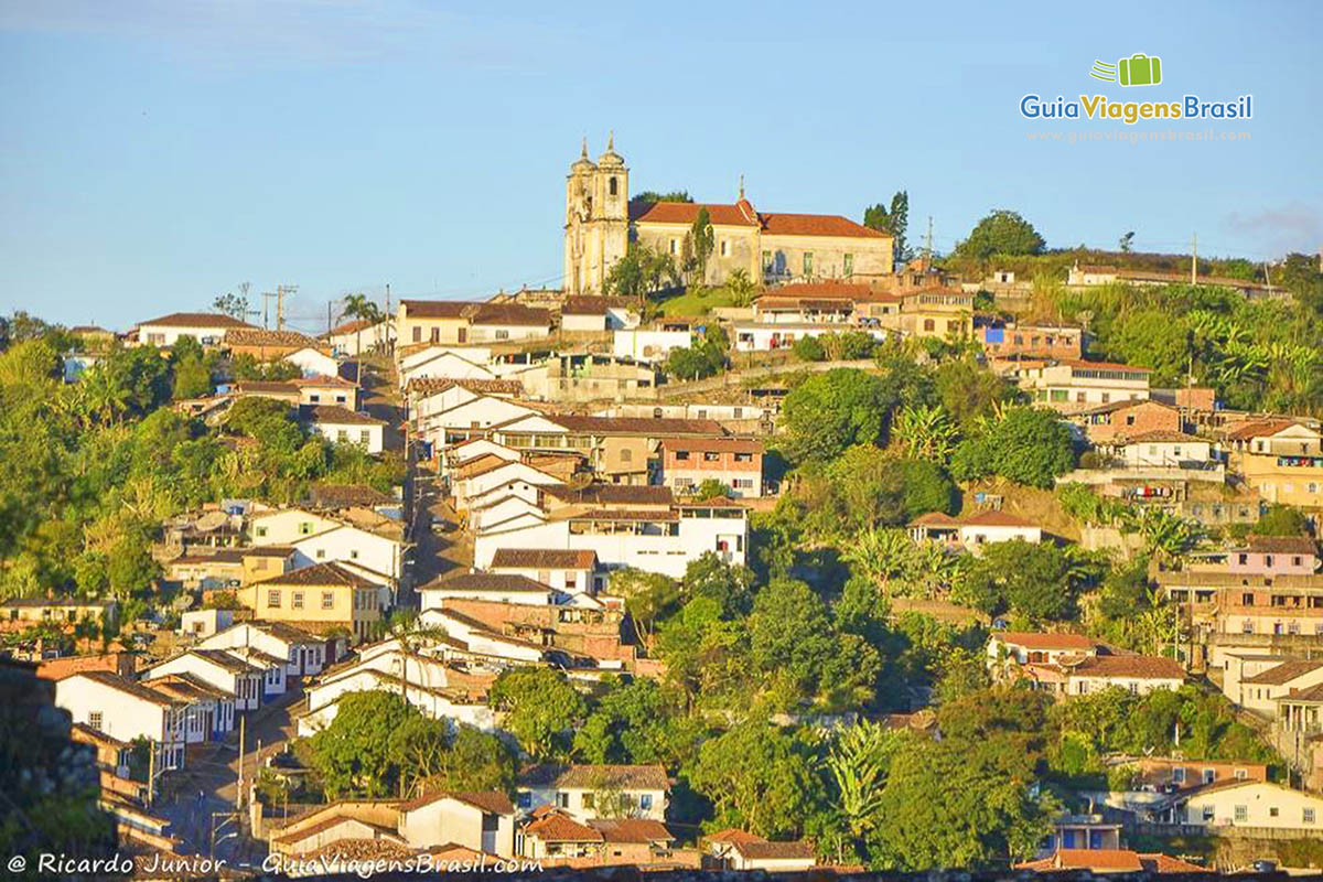 Imagem da cidade de Ouro Preto e no topo do morro igreja.