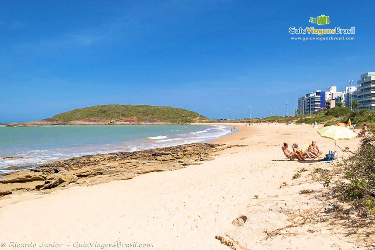 Imagem de pessoas aproveitando um belo dia de sol na praia.