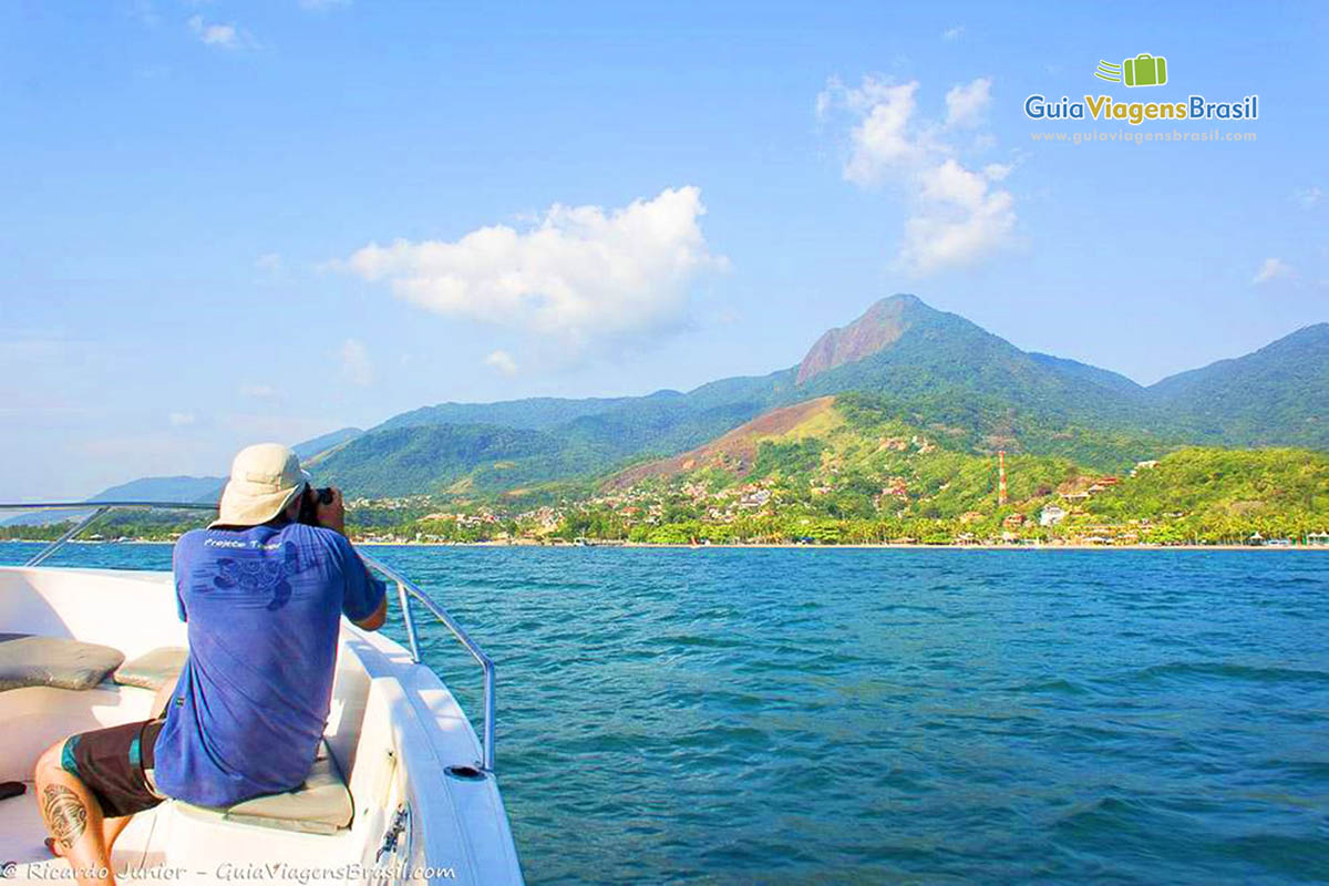 Imagem de fotógrafo registrando as belezas de Ilhabela.