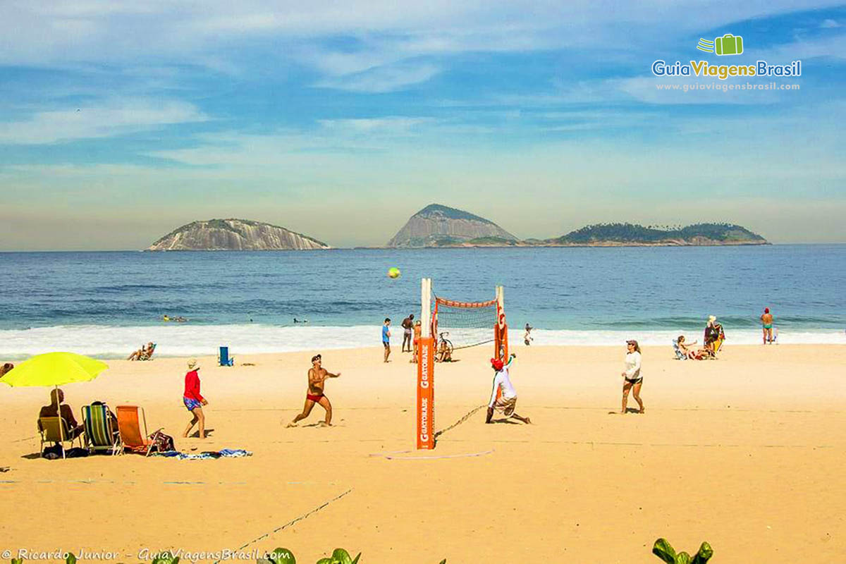 Imagem de amigos jogando futevôlei na Praia de Ipanema.