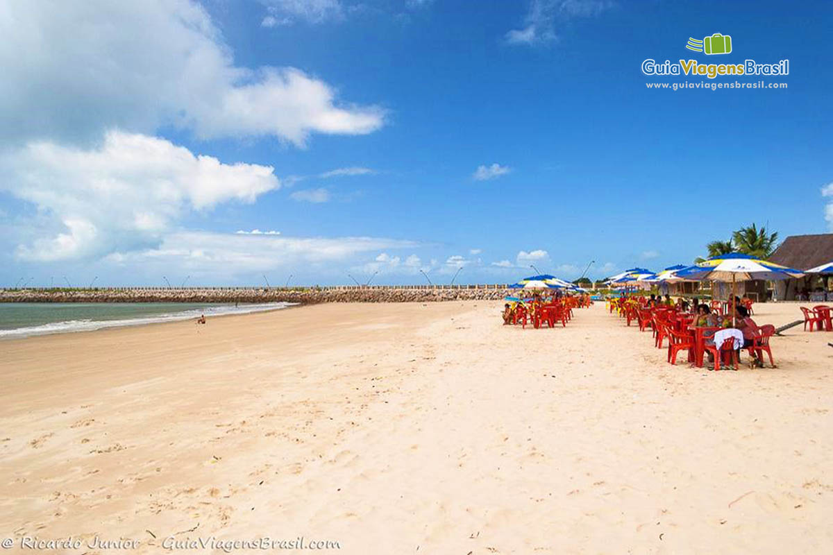 Imagem da grande faixa de areia da praia.