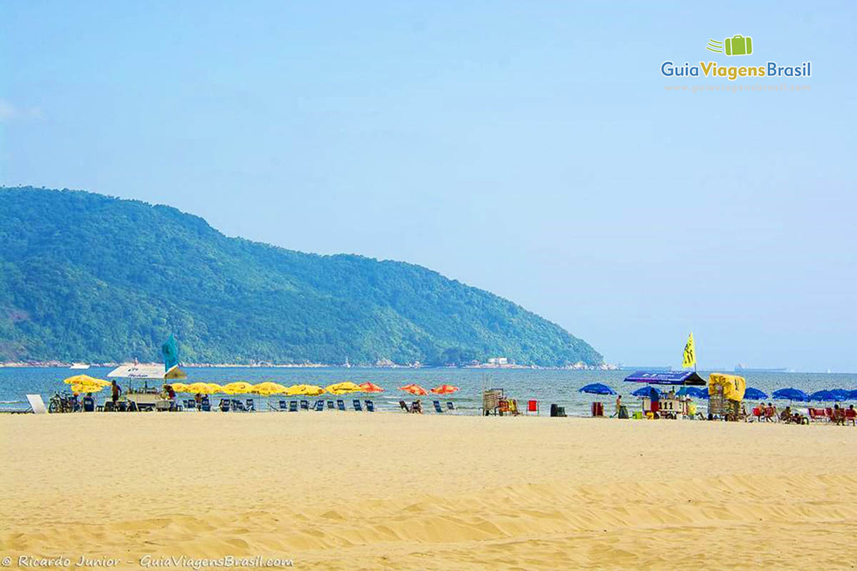 Imagem de vários guarda sol nas areias da linda praia.