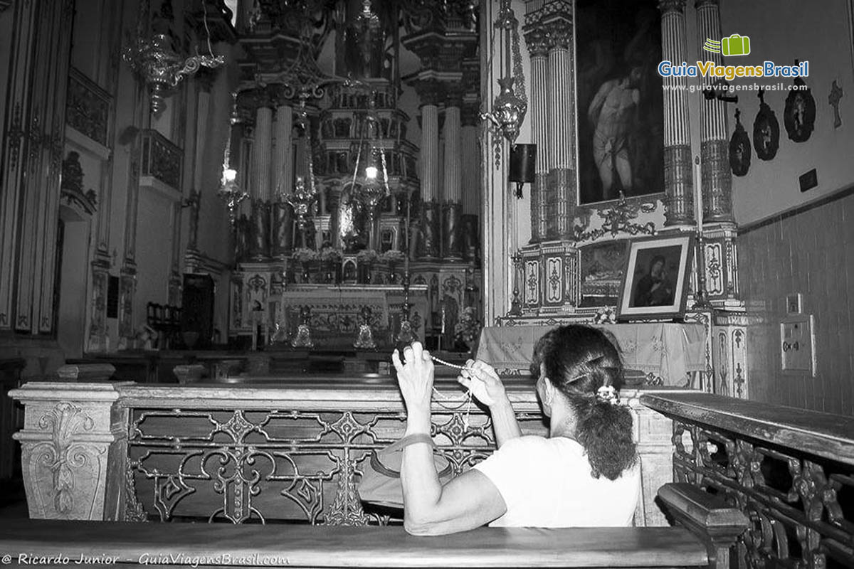 Imagem de uma devota rezando na igreja.
