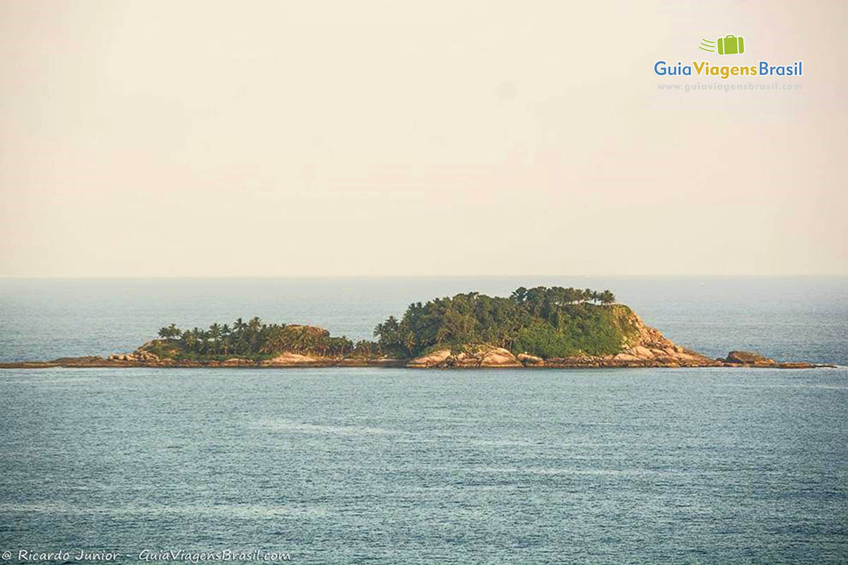 Imagem do lindo mar azul e no horizonte uma ilha.