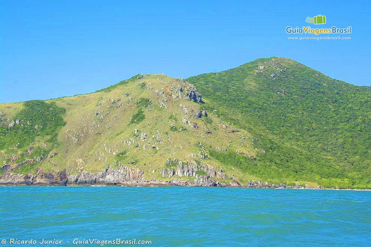 Imagem do mar azul e ao fundo a Mata Atlântica preservada.