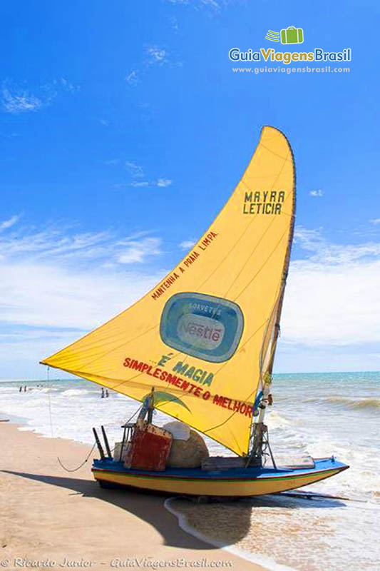 Imagem de uma jangada amarela nas areias da praia Canoa Quebrada.