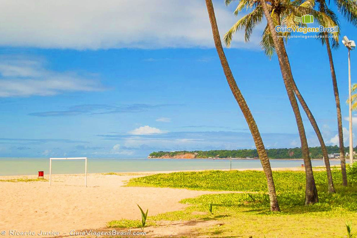 Imagem de vários turistas andando na beira da Praia Camboinha.