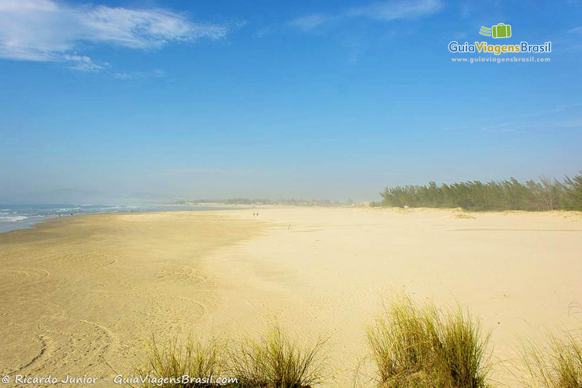 Imagem das areias douradas da bela praia.