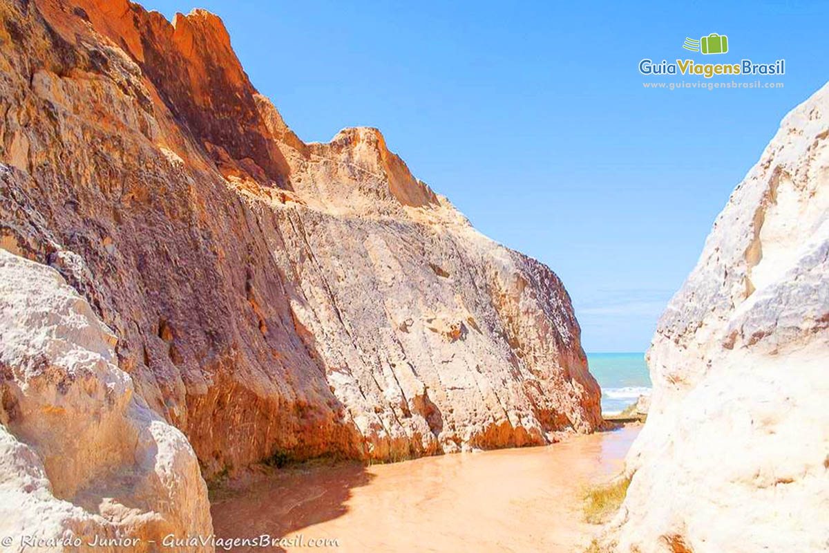 Imagem da água do mar vindo até as falesias.