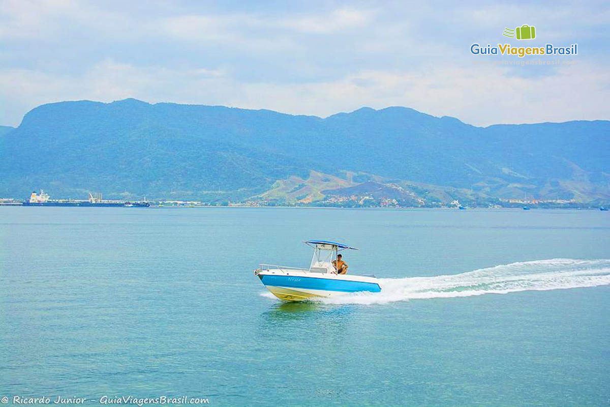 Imagem lancha azul e branca no alto mar em Ilhabela.