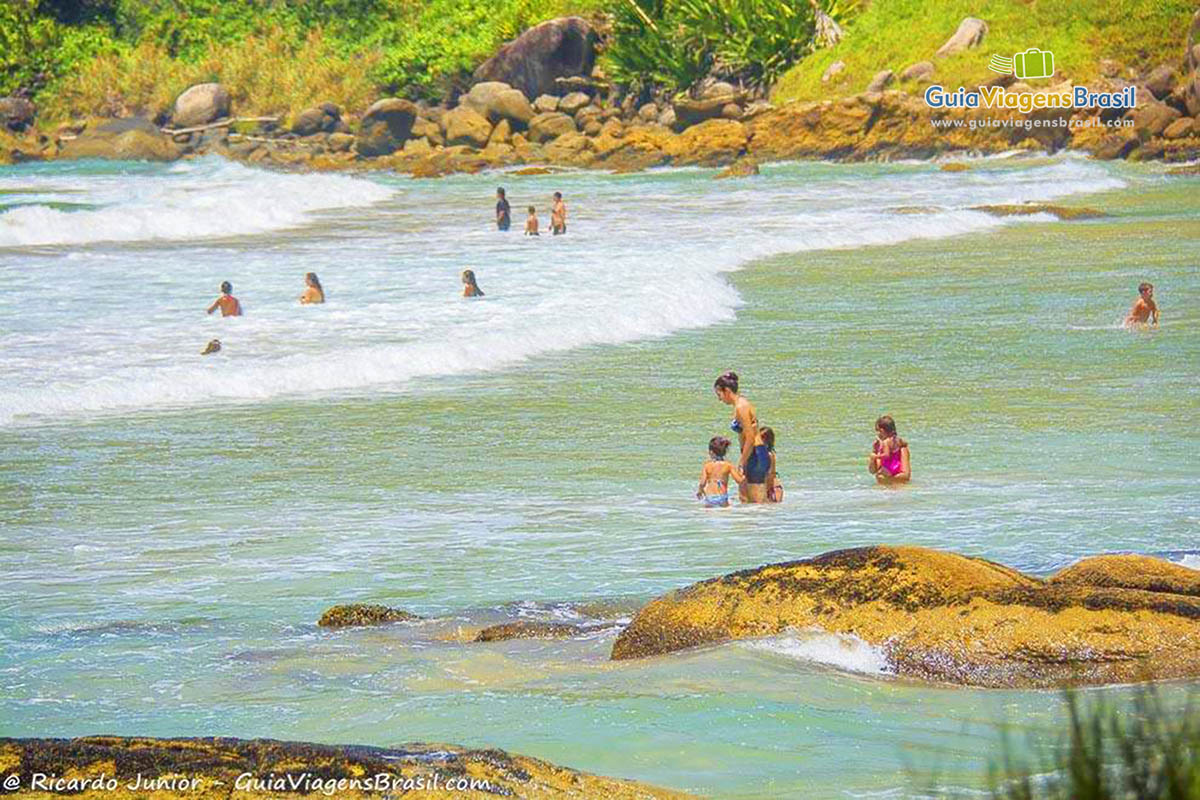 Imagem de famílias curtindo o belo dia de praia.