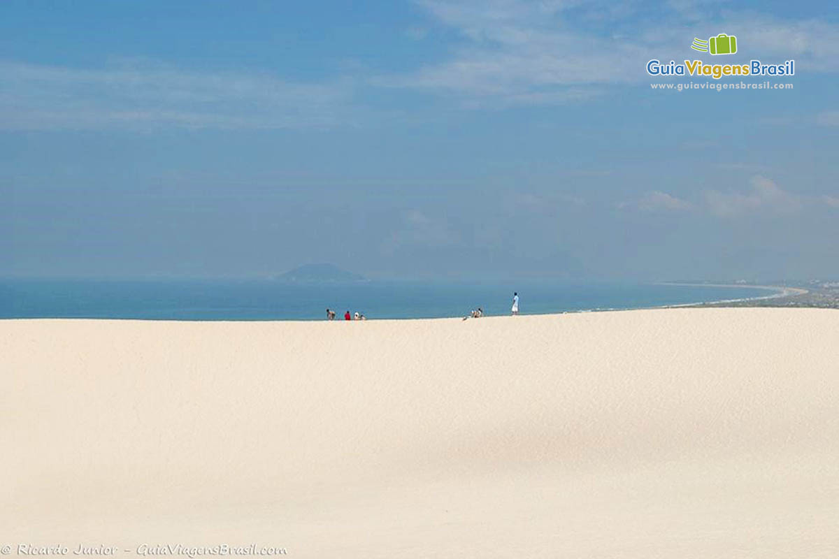 Imagem do alto das dunas e ao fundo céu maravilhoso e o mar com azul fantástico.