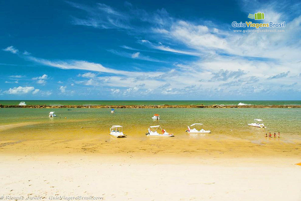 Imagem de lanchas de passeio na beira da praia em Alagoas.