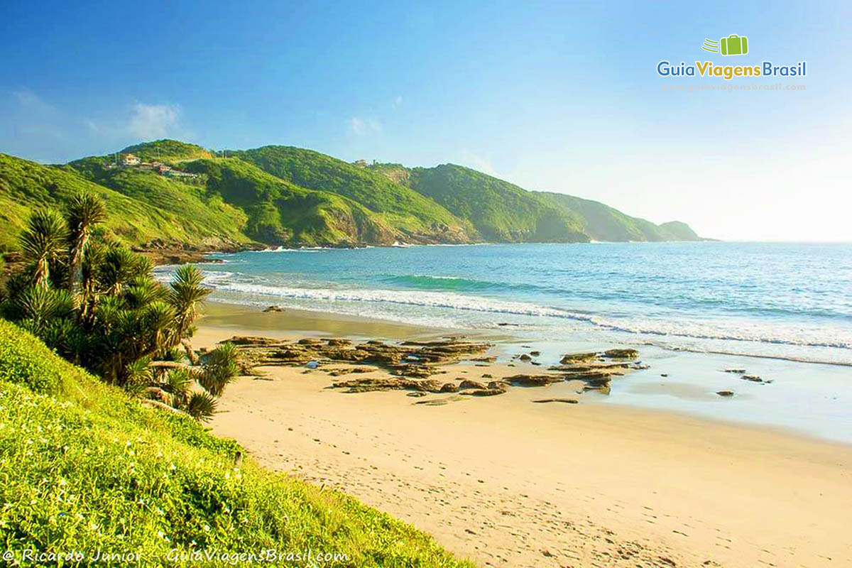 Imagem da divisa com a bela formação rochosa, dando um charme especial a praia.