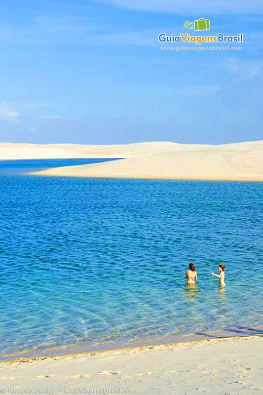 Imagem de duas meninas nas águas mornas de Santo Amaro.