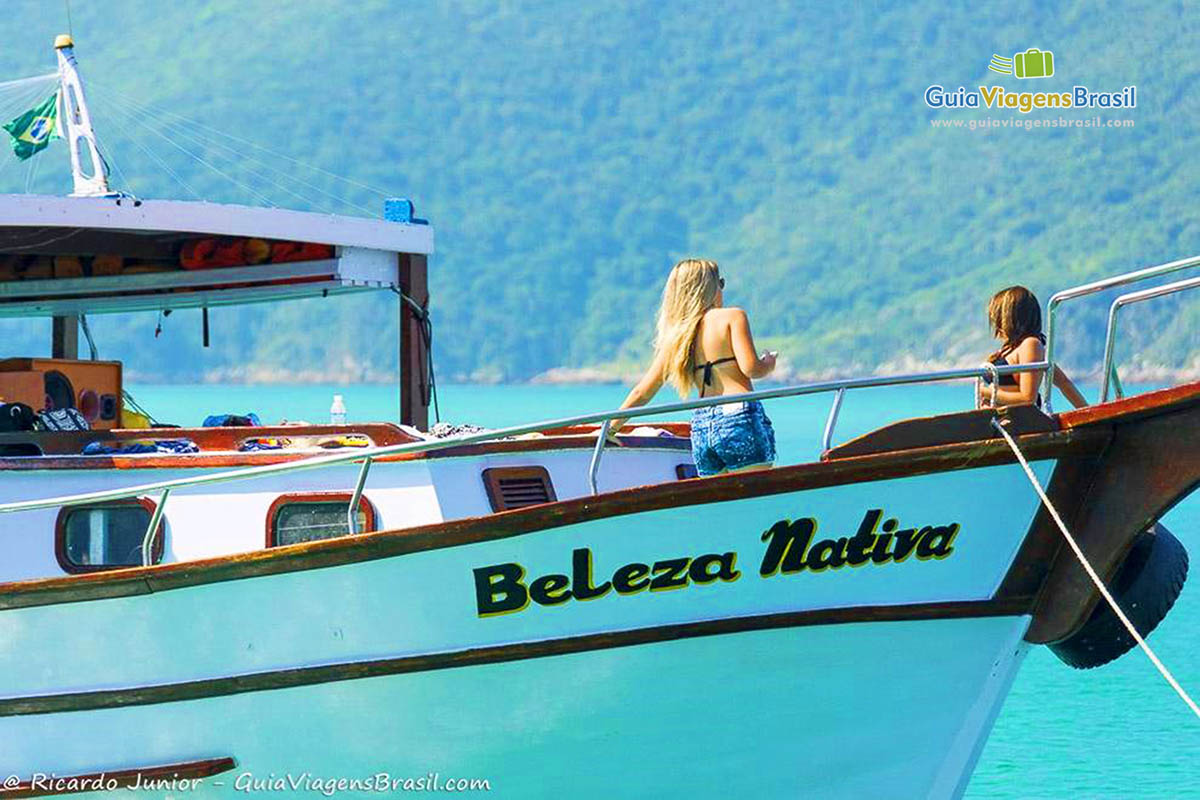 Imagem de duas amigas dentro do barco de passeio.