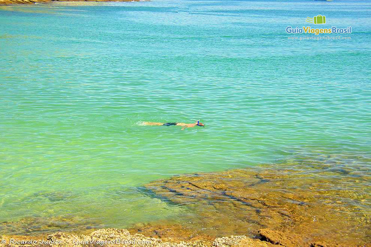 Imagem de pessoa mergulhando nas águas da praia.