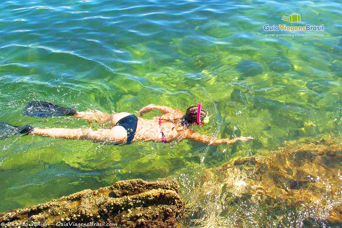 Imagem de uma pessoa mergulhando na Praia Lagoinha.
