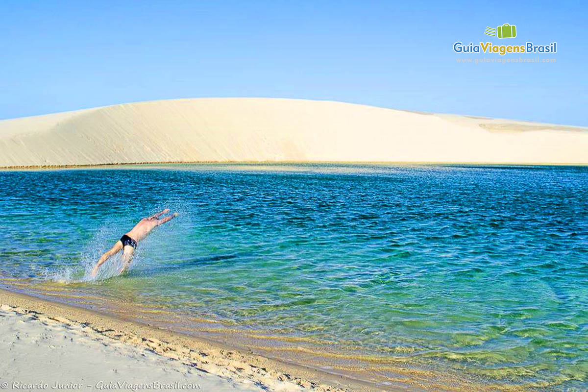 Imagem de um rapaz mergulhando nas águas da lagoa.