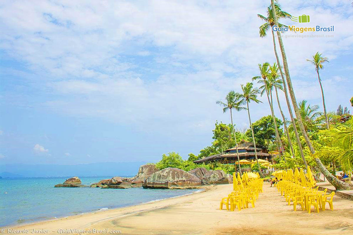 Imagem de mesas e cadeiras expostas para visitantes na linda praia.