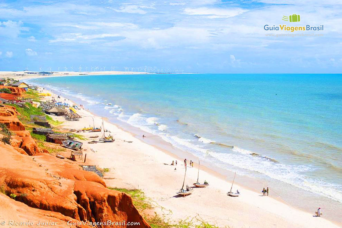 Imagem do alto de cataventos de jangadas nas areias da Praia Canoa Quebrada.