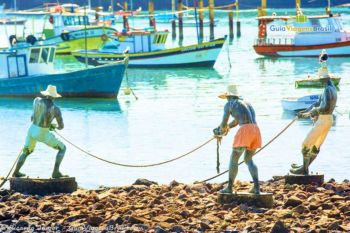 Imagem de monumento de três pescadores na Praia da Armação.