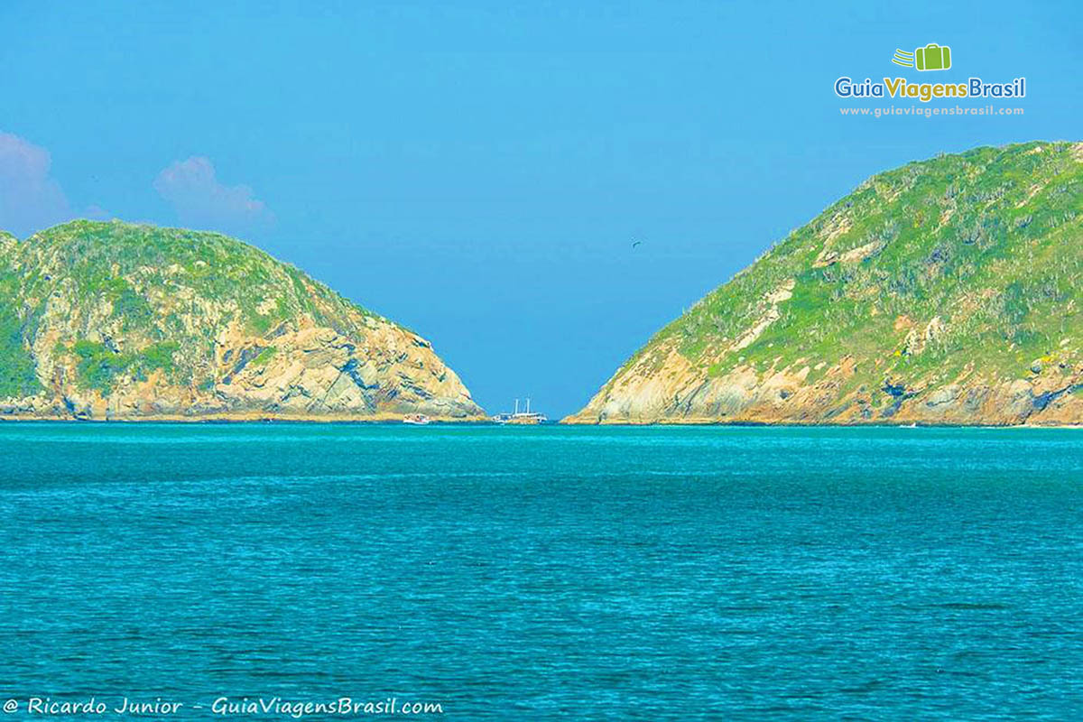 Imagem do maravilhoso mar azul e dois lindos morros.