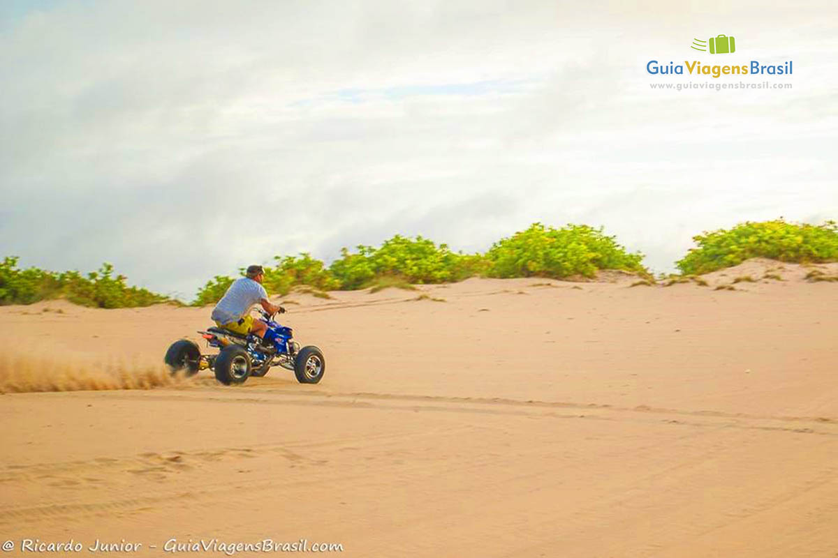 Imagem de rapaz andando de motocicleta nas Dunas.