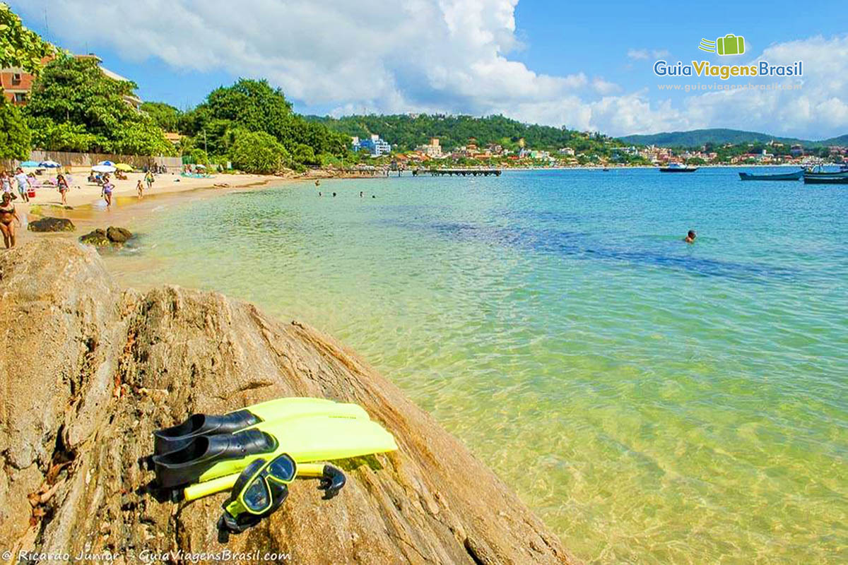 Imagem de um pé de pato e snorkel nas pedras da Praia Lagoinha.