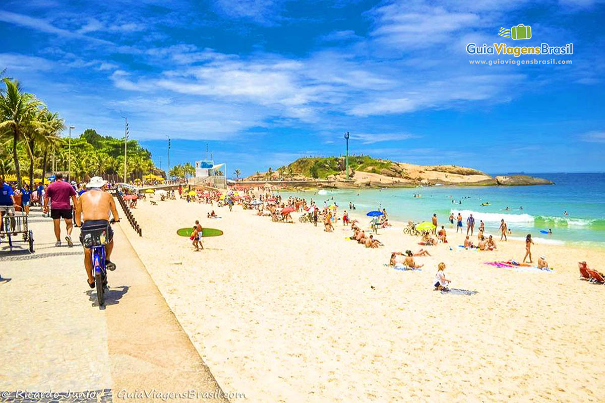 Imagem de um morador pedalando pela belíssima orla da Praia Arpoador.  