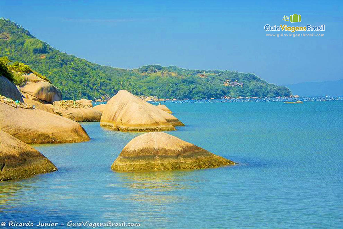 Imagem de grandes pedras nas águas do mar.