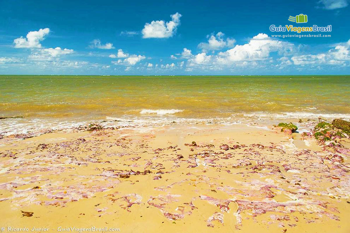 Imagem das pedras pequenas e vermelhas nas areias da Praia de Carro Quebrado.