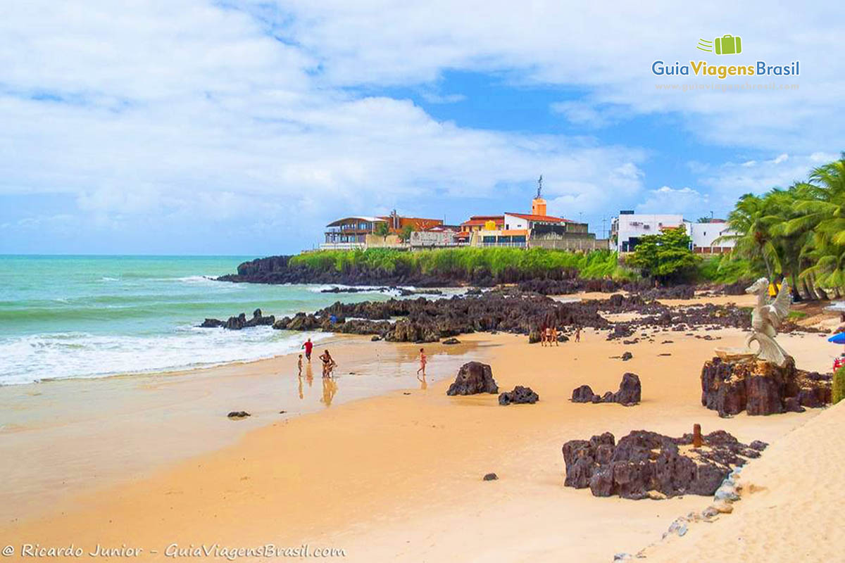 Imagem de pedras no canto da praia.