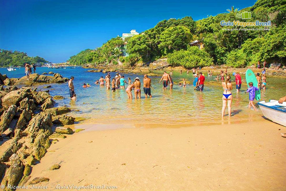 Imagem de pessoas aproveitando o dia na bela e pequena Praia Lagoinha.
