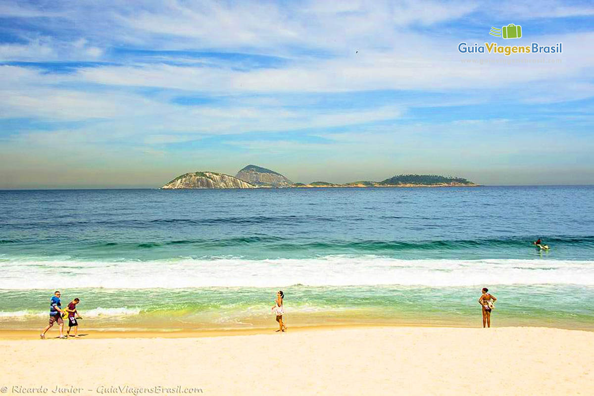 Imagem de dois turistas andando na beira da praia e amigas.