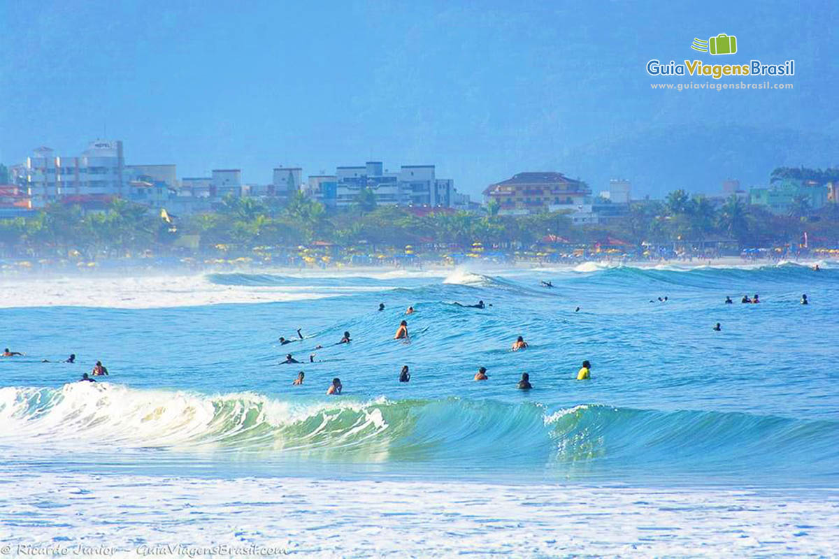 Imagem de pessoas no mar da  belíssima Praia das Toninhas.