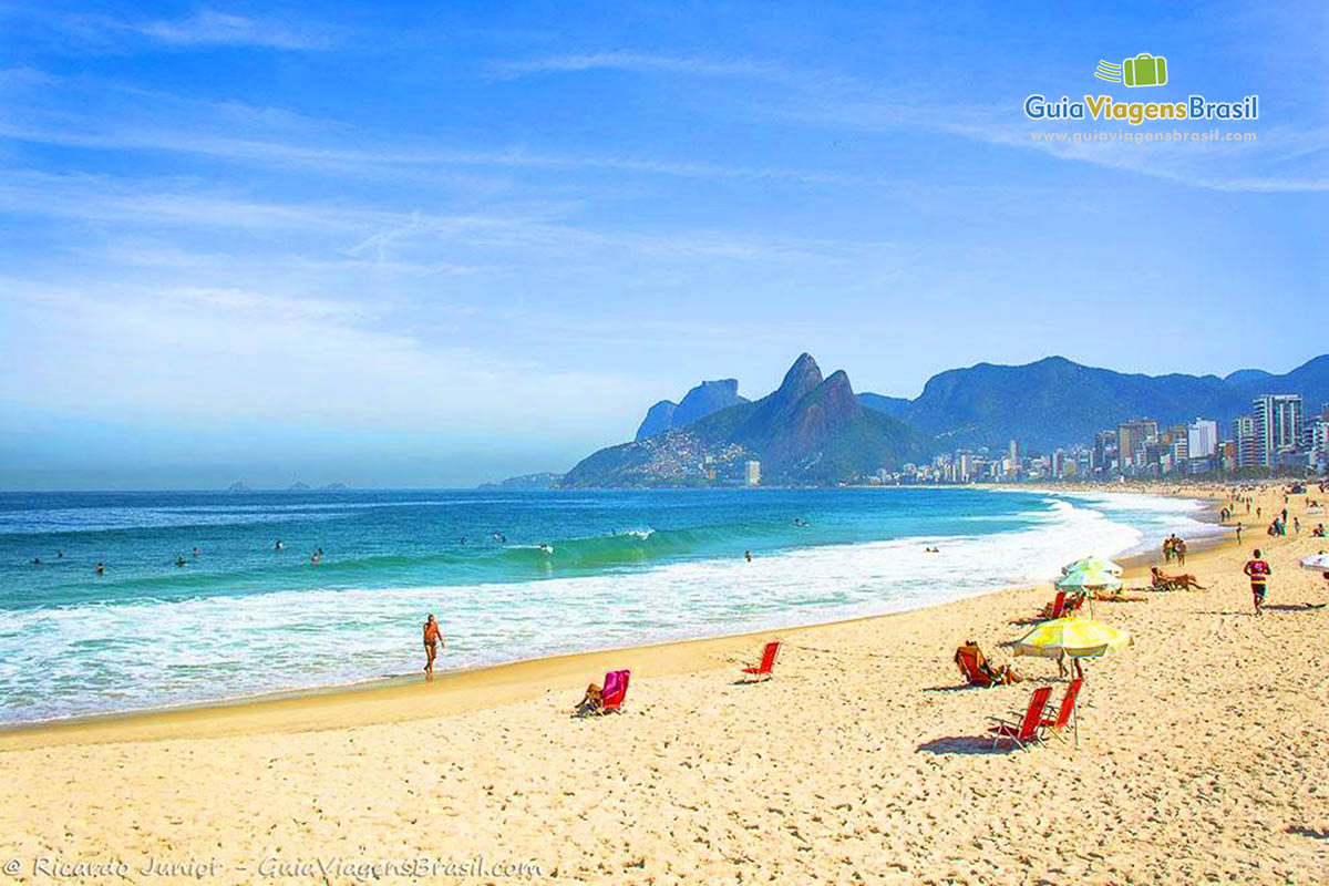 Imagem da Praia Arpoador, super democrática- pessoas na areia e no mar.