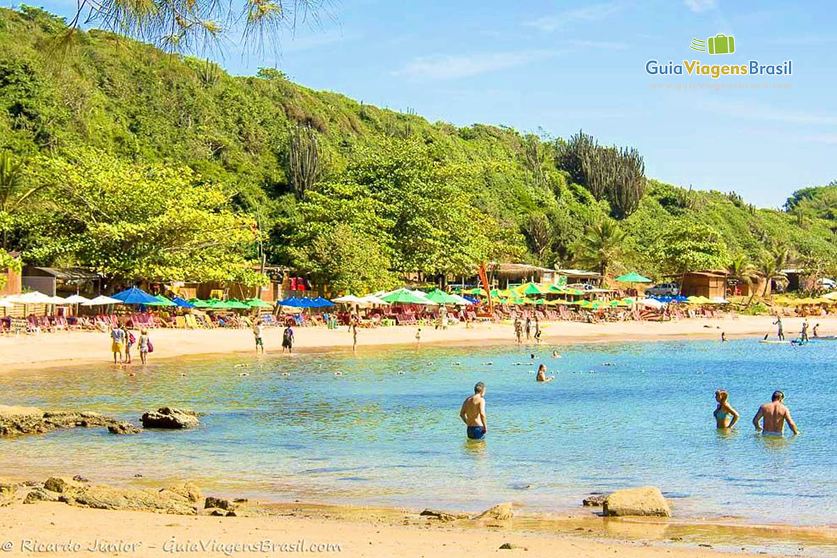 Imagem de pessoas no mar aproveitando um excelente dia de praia.